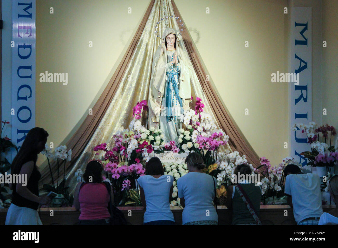 Medjugorje, August 2013. Gemeindemitglieder und Pilger beten vor einer Statue der Madonna in der Kirche von St. James. Stockfoto