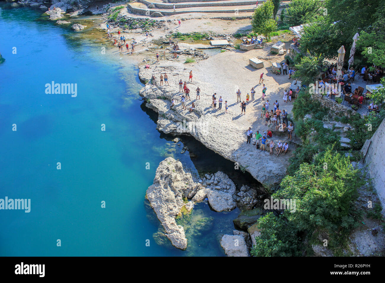 August 2013, Mostar. Touristen/Zuschauer realaxing am Ufer des Flusses Neretva warten auf die nächste Brücke Jumper/Taucher. Stockfoto