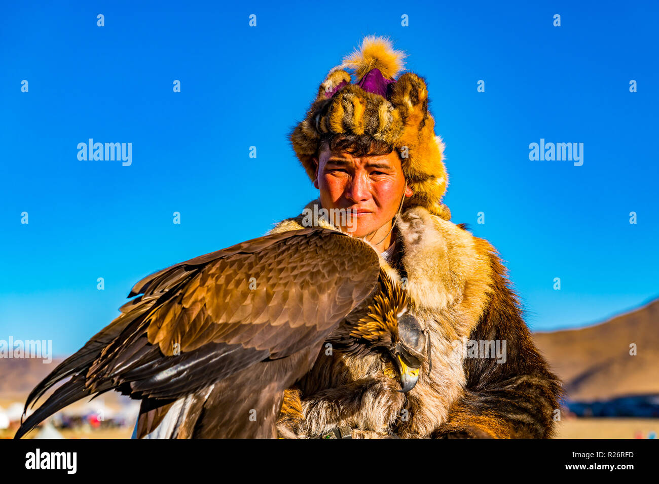 ULGII, Mongolei - OKTOBER 6, 2018: Golden Eagle Festival. Mongolische Golden Eagle Hunter in der traditionellen Kleidung der Fuchs Fell mit Adler auf seiner Hand in Stockfoto