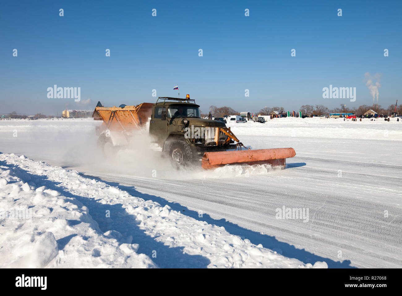 Schneepflug ist die Reinigung einer Straße und Schnee fliegen um es Stockfoto