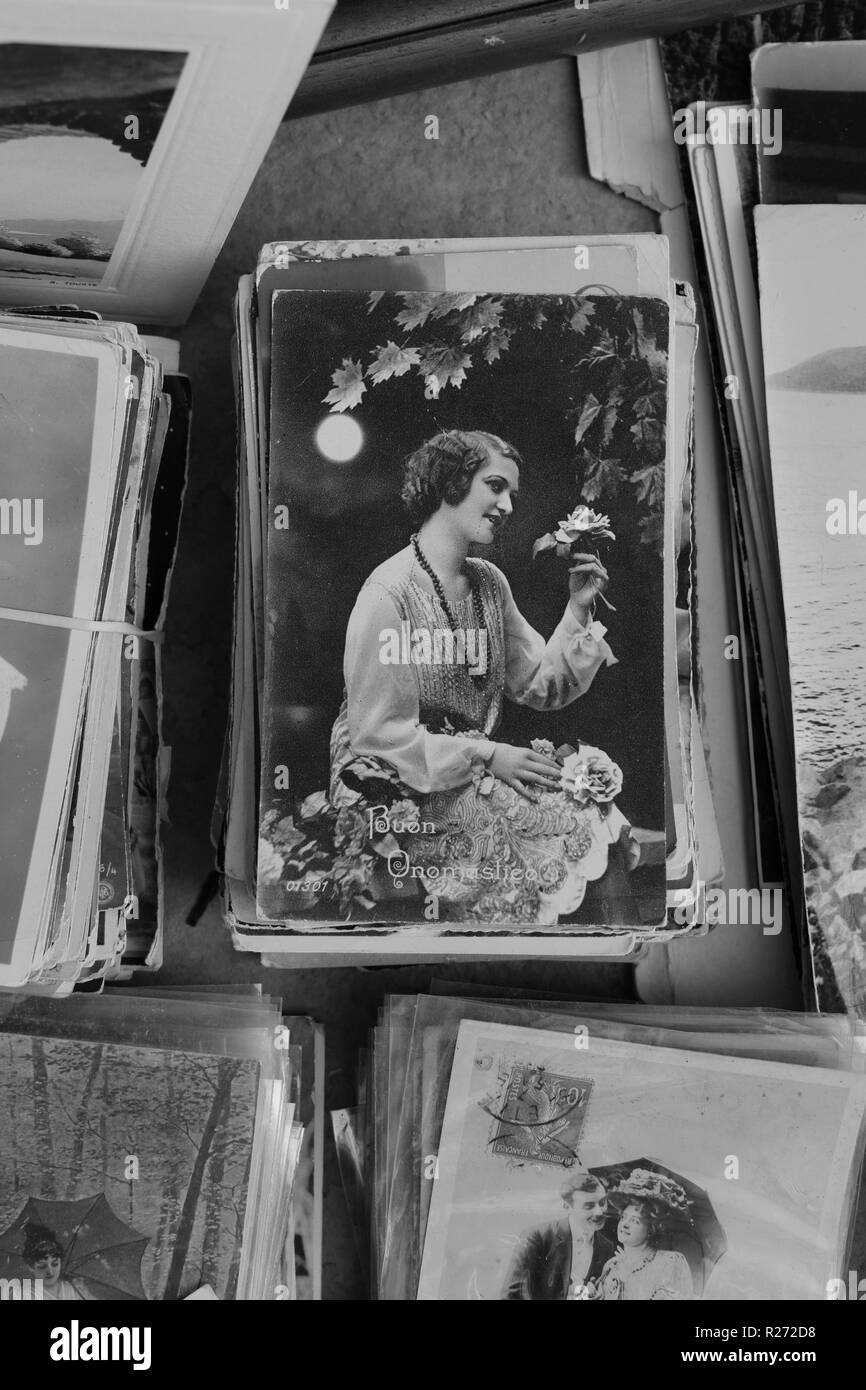 Athen, Griechenland - 14. SEPTEMBER 2018: Alte Ansichtskarte der jungen Frau mit Rosen unter Moonlight und alten Fotografien zum Verkauf an Antiquitäten. Schwarz Stockfoto