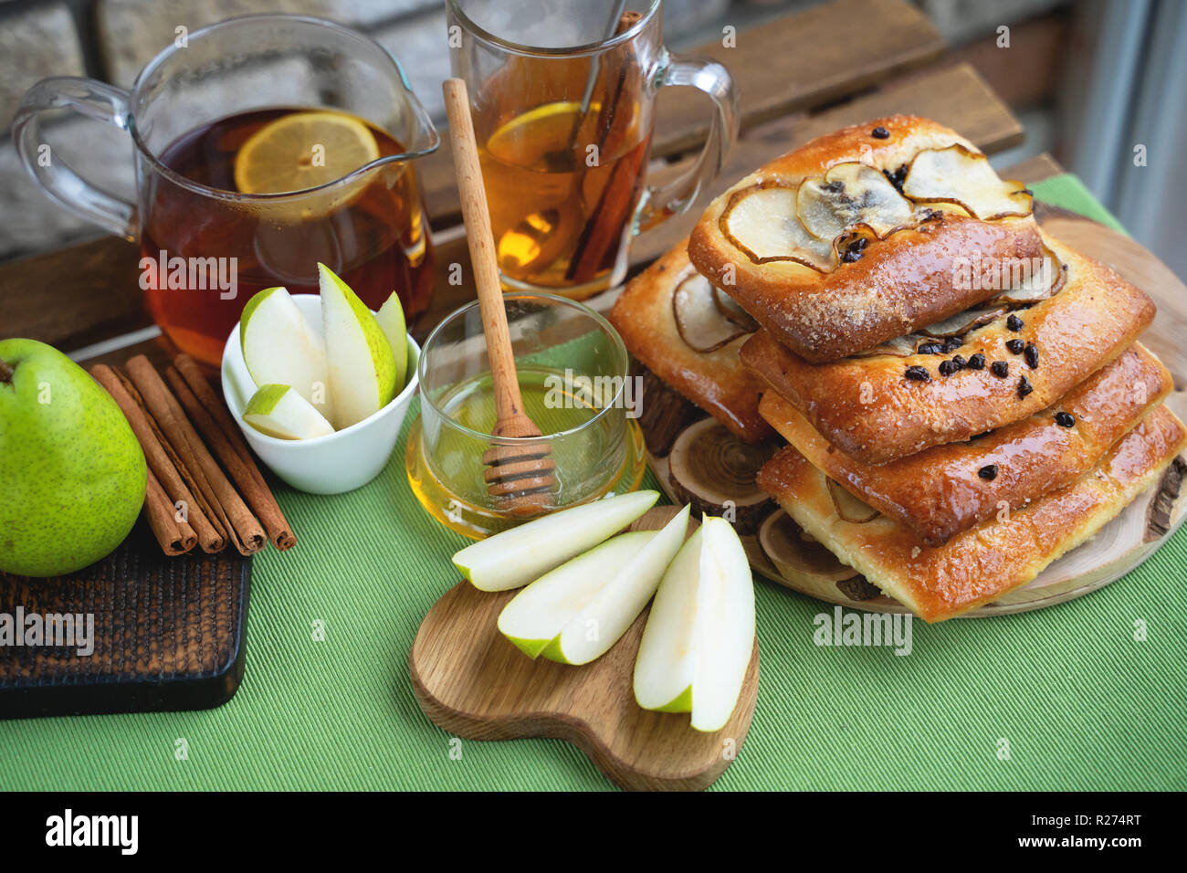 Französische brioche Brötchen mit Birne, Honig und Tee auf hölzernen Tisch Stockfoto