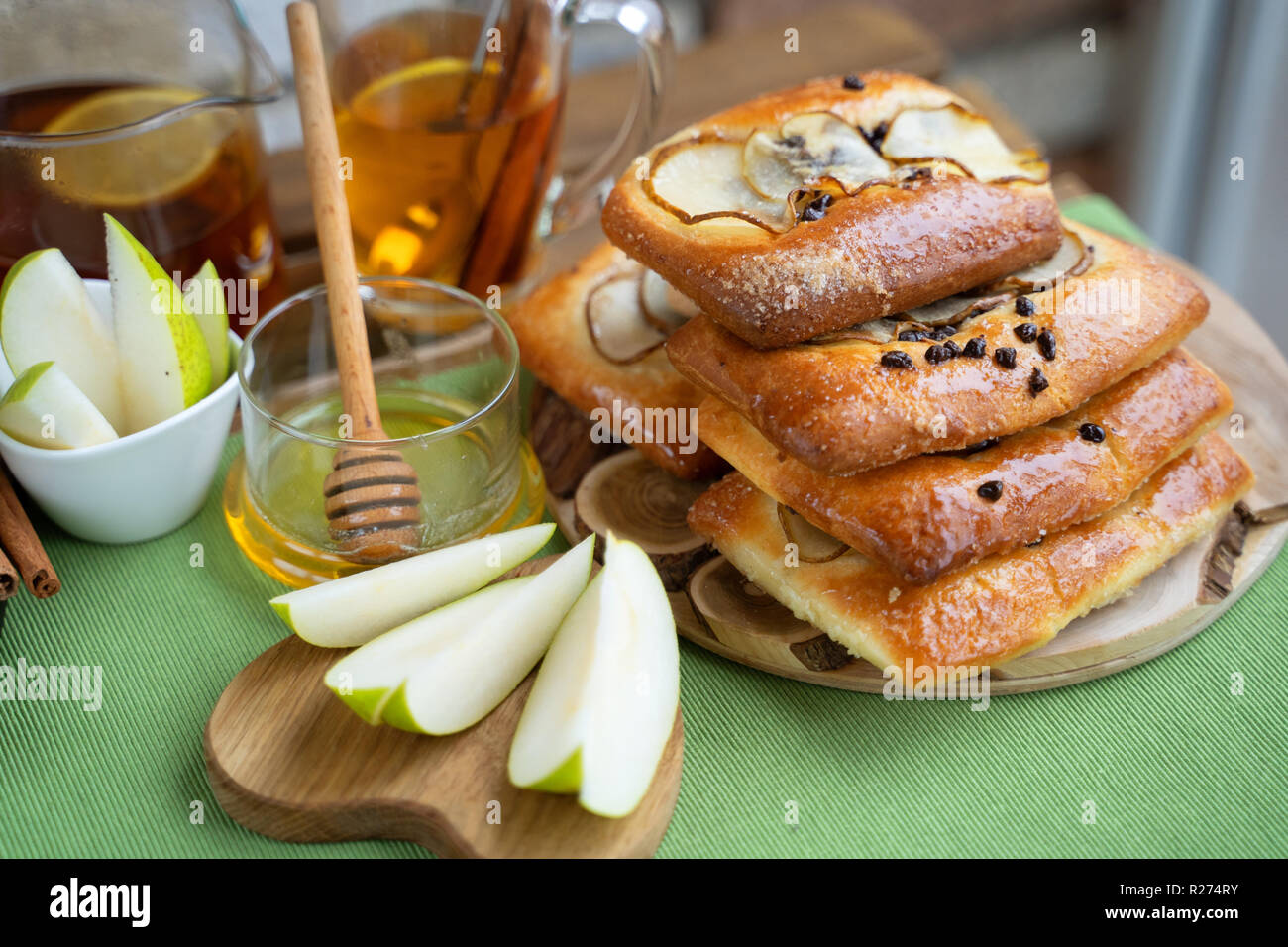 Französische brioche Brötchen mit Birne, Honig und Tee auf hölzernen Tisch Stockfoto