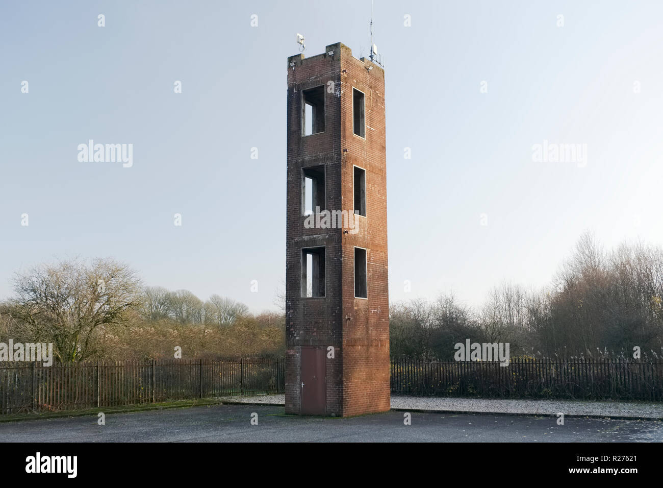 Tower für Feuerwehr Notfalltraining Praxis und Leiter gegen rote Backstein und leere Himmel Stockfoto