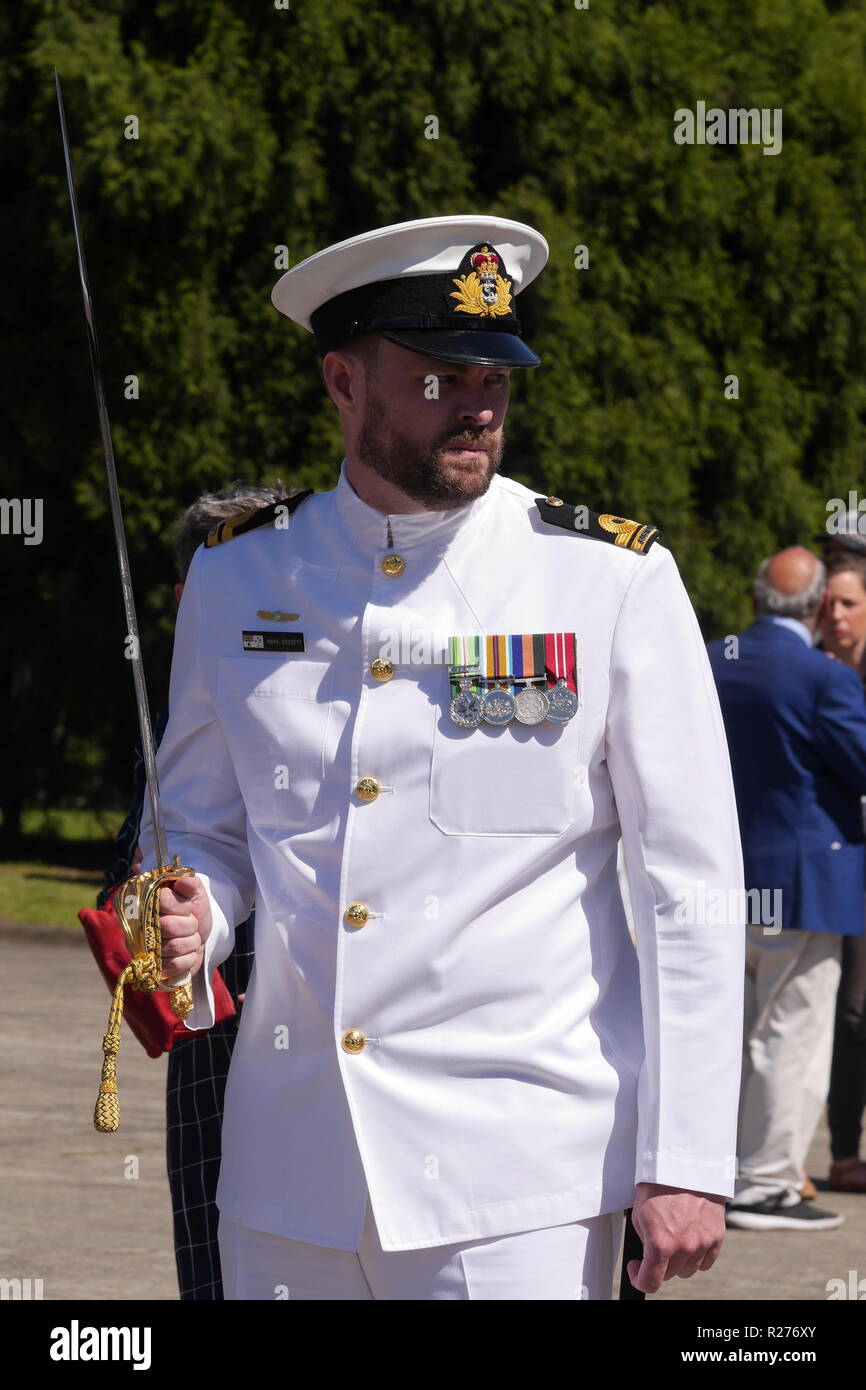 Vertikale Bild des bärtigen Australische Marineoffizier Gekleidet in weiße Uniform holding Schwert auf der linken Seite üben marschieren für die Zeremonie. Stockfoto