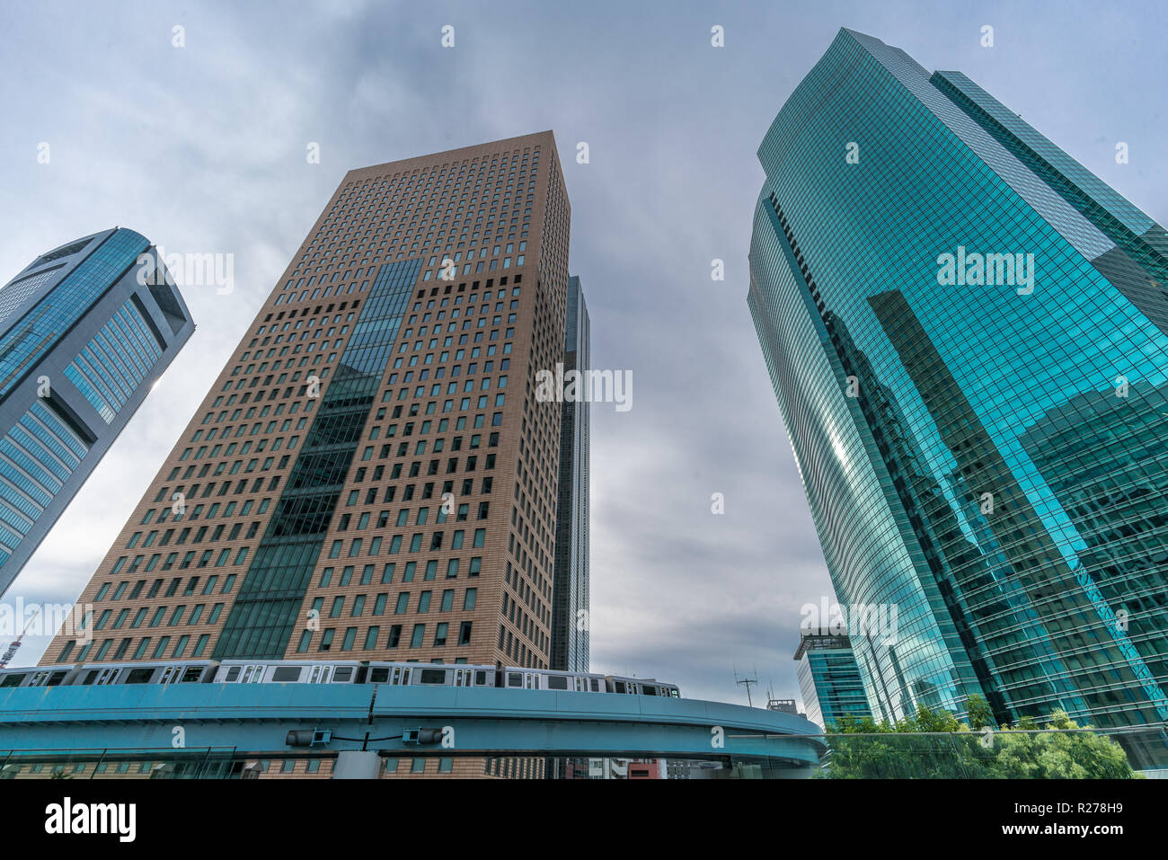 Minato Bezirk, Tokyo, Japan - 19 August 2018: Yurikamome Linie Zug durch Wolkenkratzer, Gebäude in der Nähe von Higashi-Shimbashi Bereich. Shiodome Tower, Stockfoto