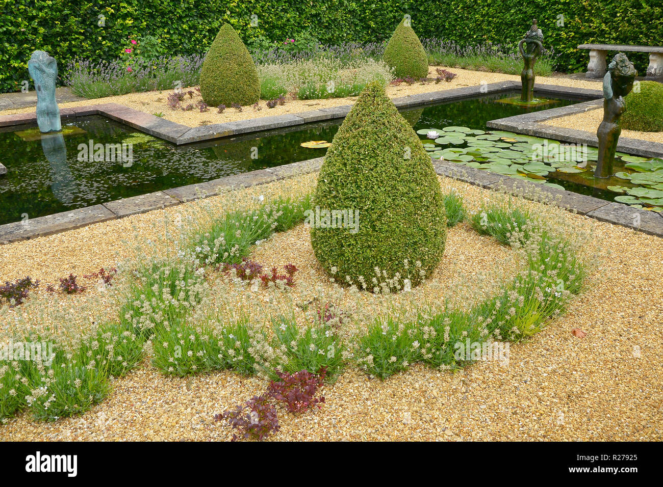 Wasserspiel IN EINEM LAND HAUS GARTEN. AUGUST 2018. OAKHAM, Rutland, England. Eine decortive formale Wassergarten mit Formschnitten und Statuen Stockfoto