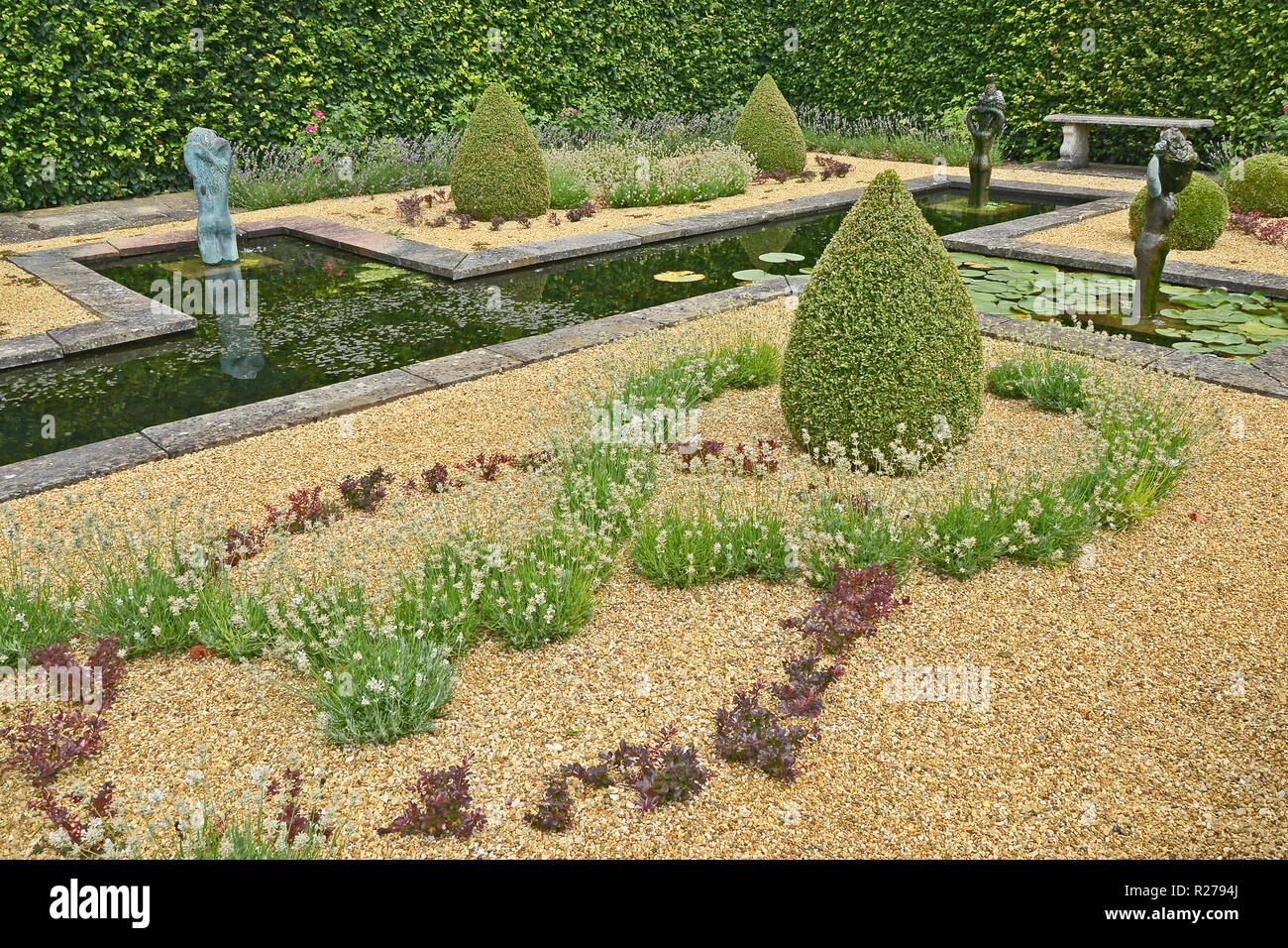 Wasserspiel IN EINEM LAND HAUS GARTEN. AUGUST 2018. OAKHAM, Rutland, England. Eine decortive formale Wassergarten mit Formschnitten und Statuen Stockfoto