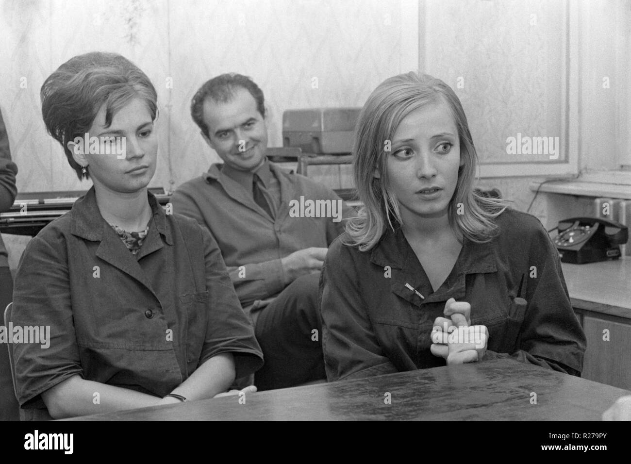 Nervös auf der Suche Mitarbeiterin setzte sich mit Kollegen in einem Büro für ein Treffen 1970 s Ungarn Stockfoto