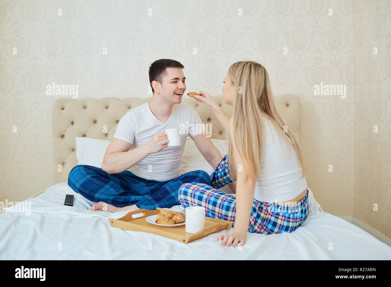 Ein junges Paar ist beim Frühstück am Morgen im Bett. Stockfoto