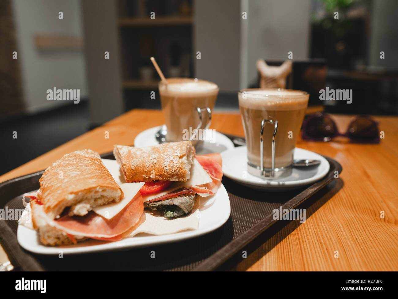 Frühstück Snack - Kaffee Latte und bocadillo Sandwich am Tisch in einem Cafe Stockfoto