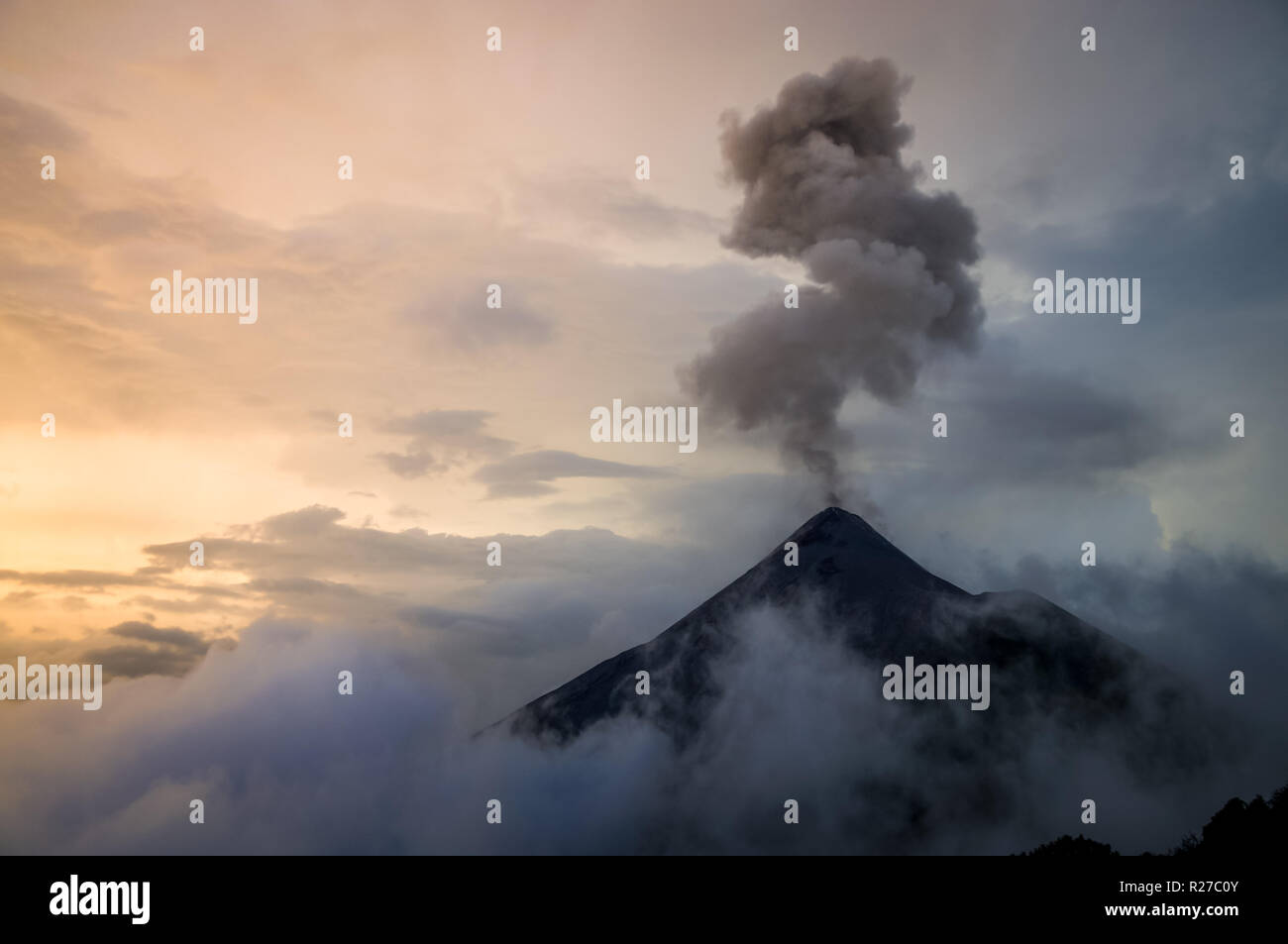 Ausbruch des Vulkans Fuego bei Sonnenuntergang mit einer wunderschönen cloudscape. Guatemala als Reiseziel. Stockfoto