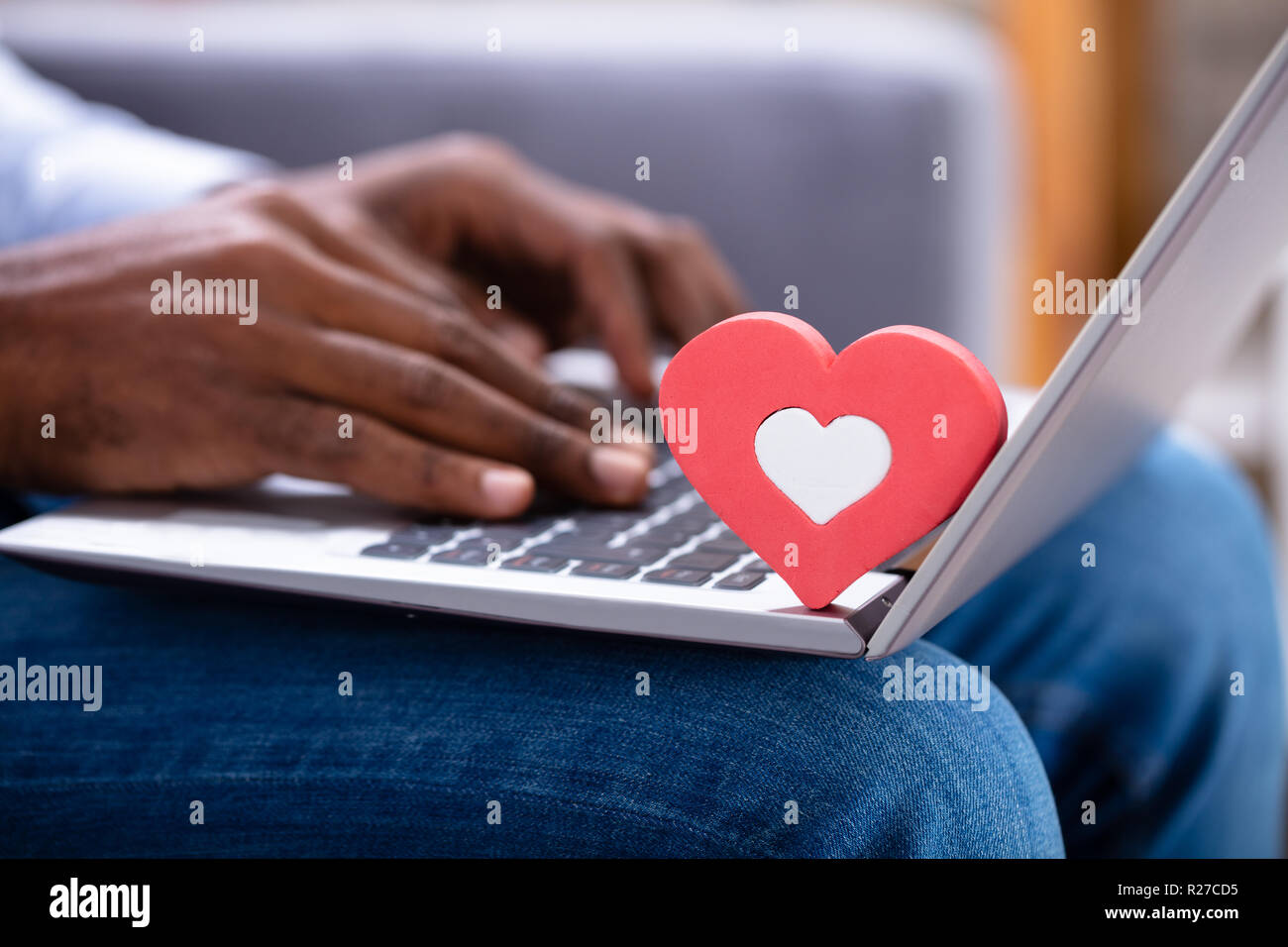 Nahaufnahme von roten Heartshape auf der Tastatur während des Menschen Hand mit Laptop Stockfoto