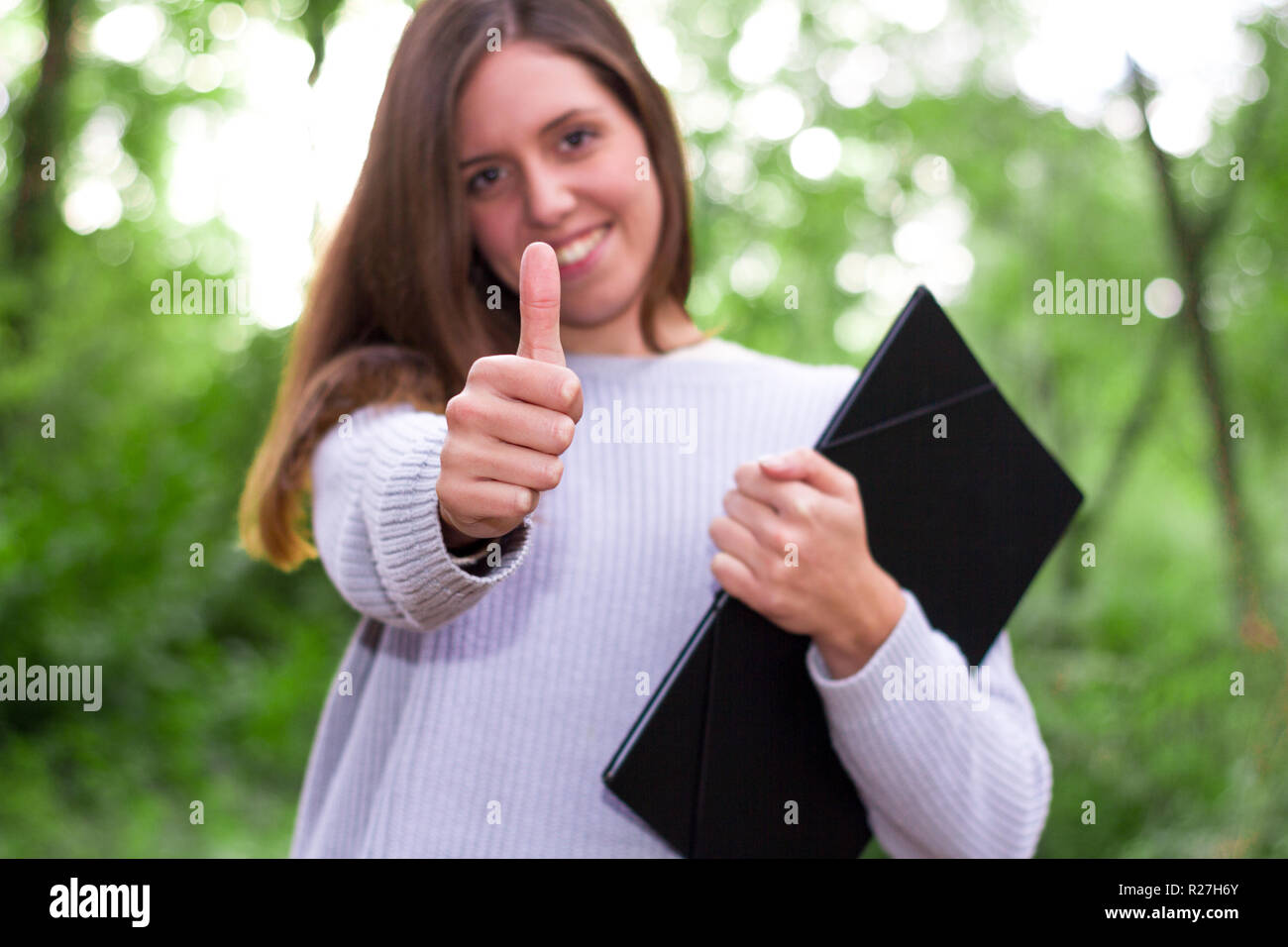 Frau oder jungen kaukasischen europäischen College Mädchen oder Student mit affirmativen Gestus Daumen hoch halten einen Ordner nach Englisch Klassen Stockfoto