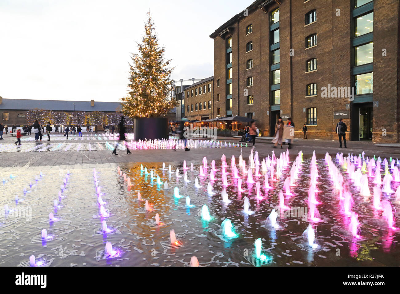Der Weihnachtsbaum und farbigen Springbrunnen in der Kornkammer Square, Kings Cross, London, UK Stockfoto