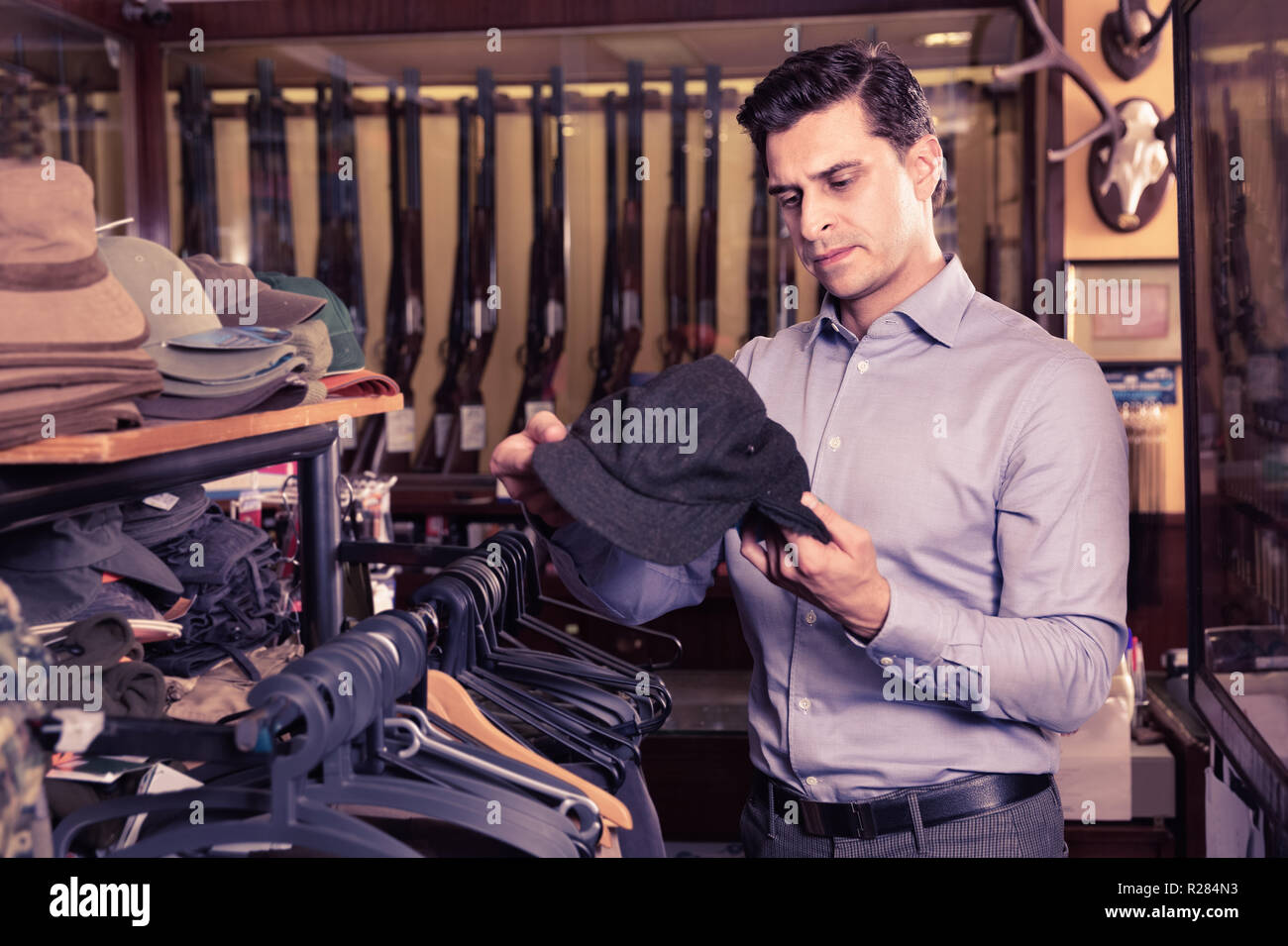 Portrait von Heiter froh Mann Auswahl Jagd Outfit im Shop Stockfoto