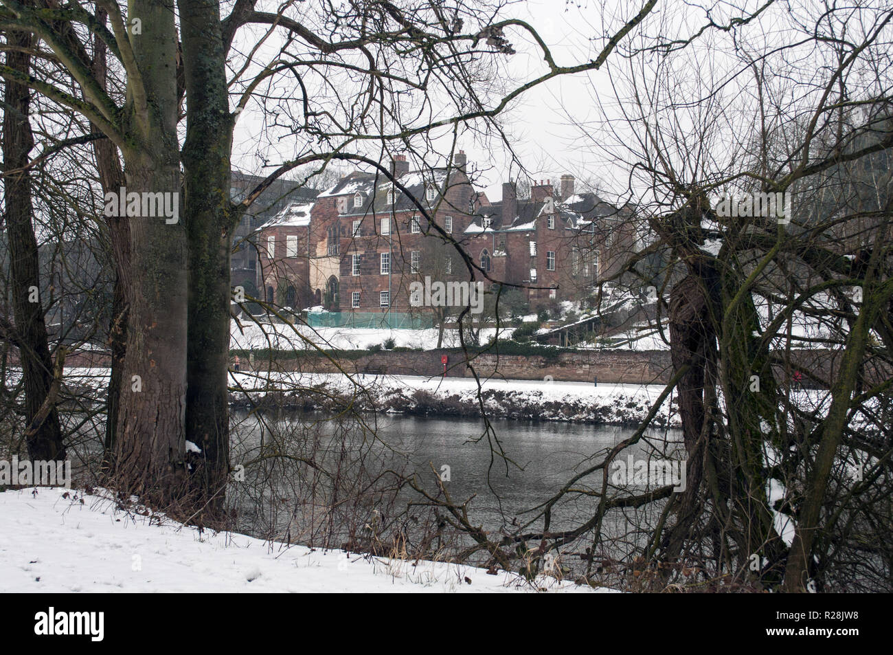 Der Blick durch die Bäume auf einem riesigen Viktorianischen verschneiten Landsitz am Flussufer von Worcester. Stockfoto