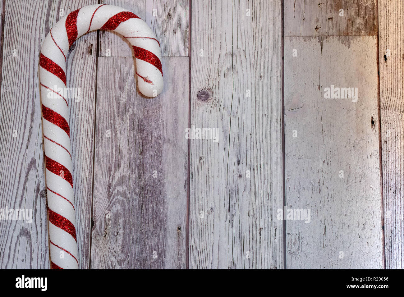 Weihnachtsfeiertag flatlay mit riesigen roten und weißen Glitzer Zuckerstange, Links auf Holz Hintergrund ausgerichtet Stockfoto