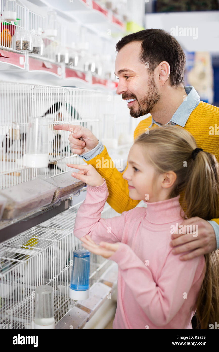 Lächelnd Mann und Tochter Auswahl am besten Vogel in Pet Shop zu halten Stockfoto