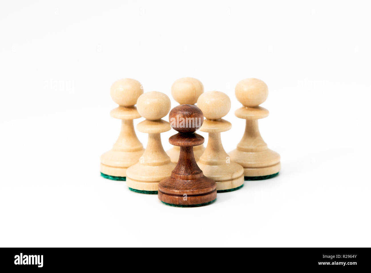 Sechs schach Schachfiguren in der Pyramide Form - fünf Weiße an der Basis, ein Schwarzer an der Spitze. Auf weissem Hintergrund. Stockfoto