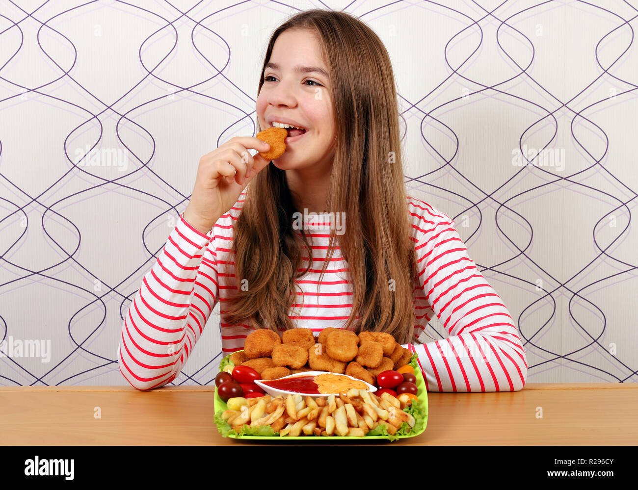 Hungrig Jugendmädchen isst Chicken Nuggets fast food Stockfoto