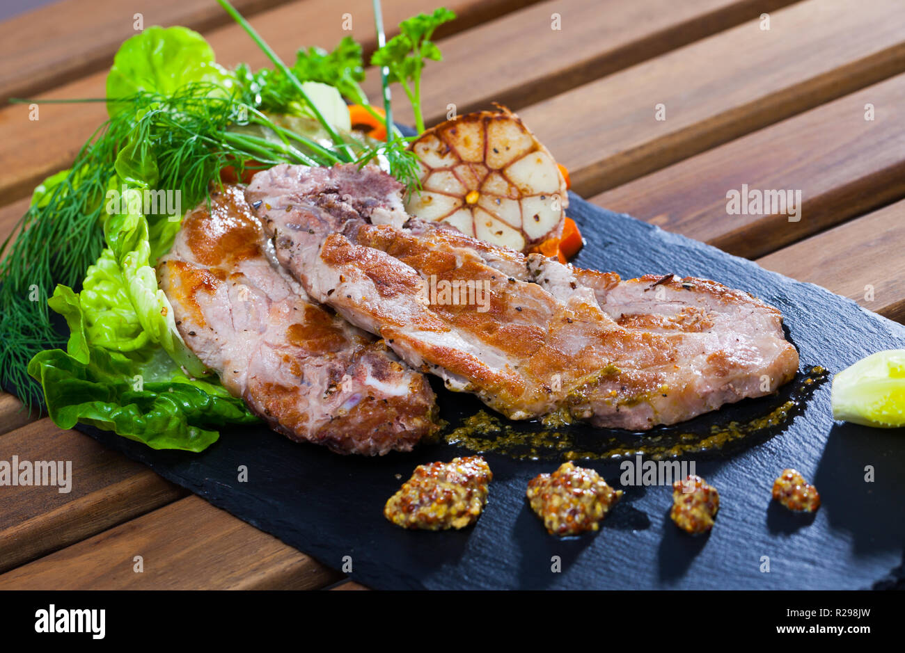Saftig gebratenes Schweinekotelett mit goldenen Kruste mit grünen, Senf ...