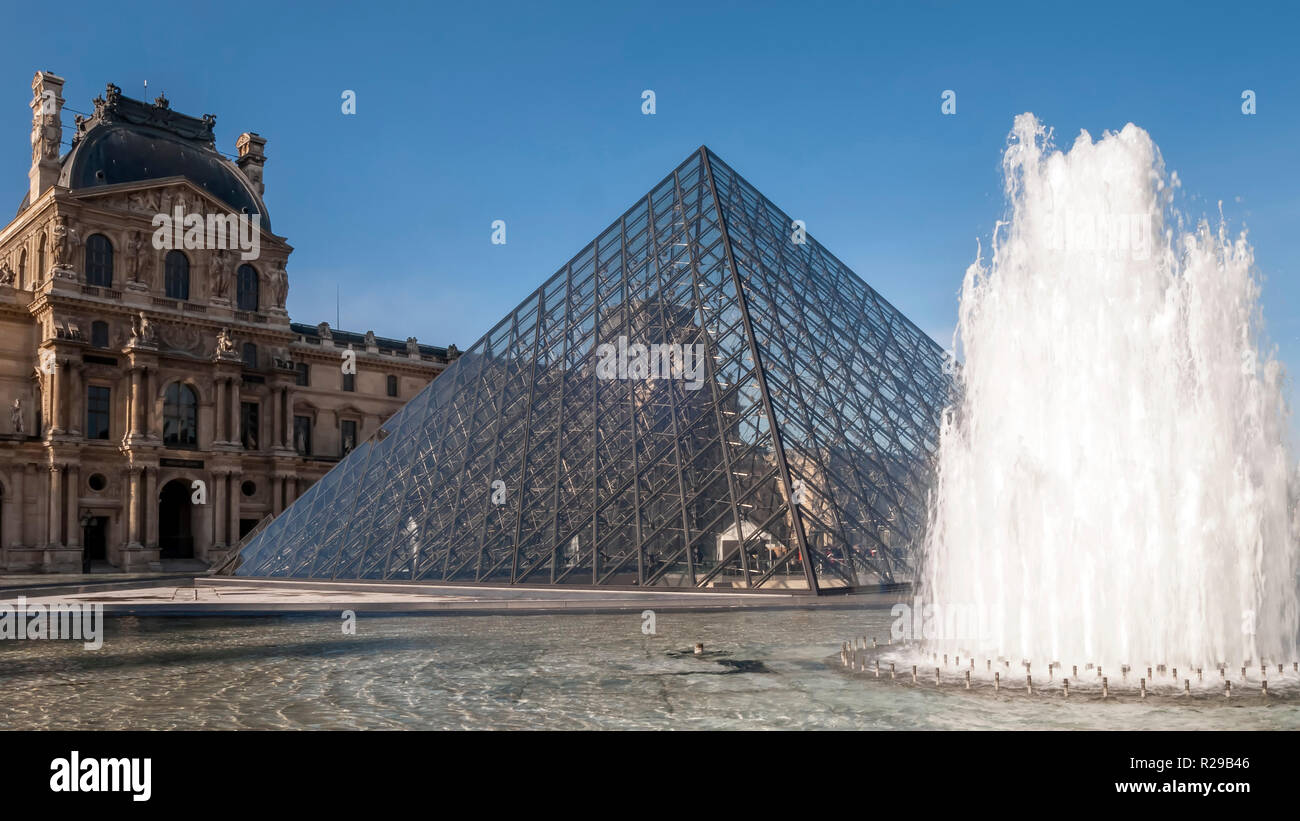 Schönen Blick auf den Louvre Pyramide mit Brunnen und Wasserstrahlen in Aktion, Paris, Frankreich Stockfoto