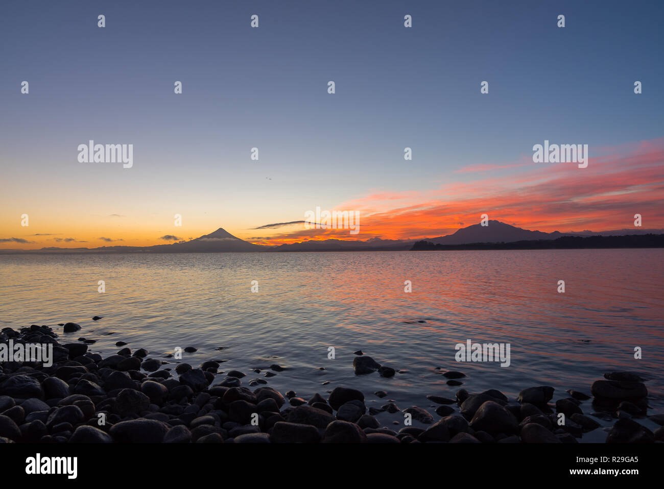 Landschaft bei Sonnenaufgang am Lago Llanquihue mit Vulkan Osorno und Calbuco im Hintergrund, Südchile Stockfoto