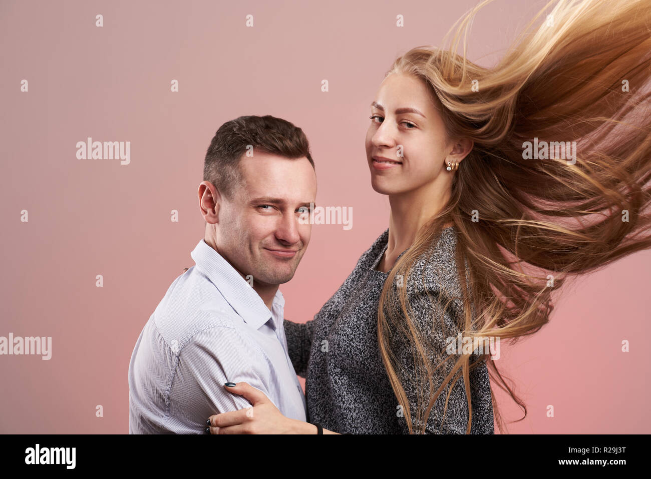 Lächelnden jungen Mann mit Frau umarmen auf rosa Hintergrund Stockfoto