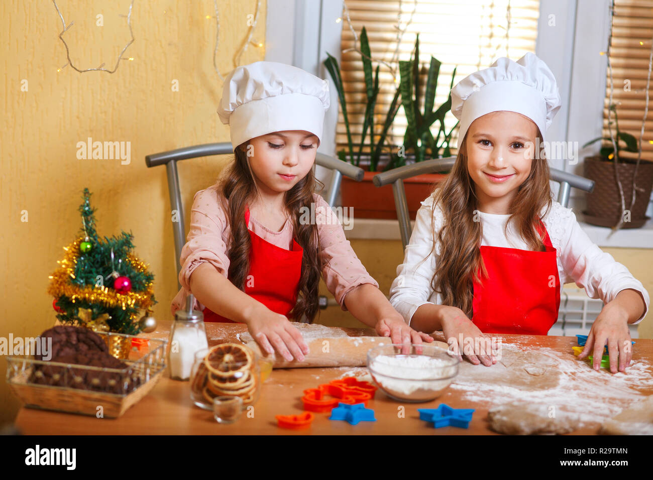 Zwei süße kleine Mädchen Vorbereitung Weihnachtsplätzchen in der Küche zu Hause. Stockfoto