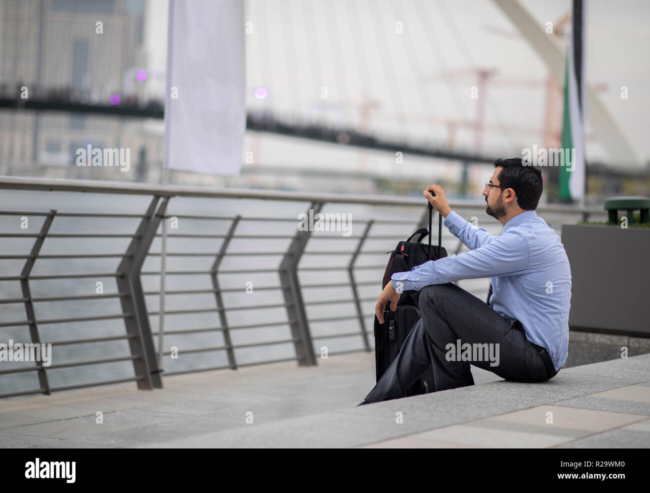 Arabische Geschäftsmann mit seinem Koffer in einer Stadt, die sich auf Treppen Stockfoto