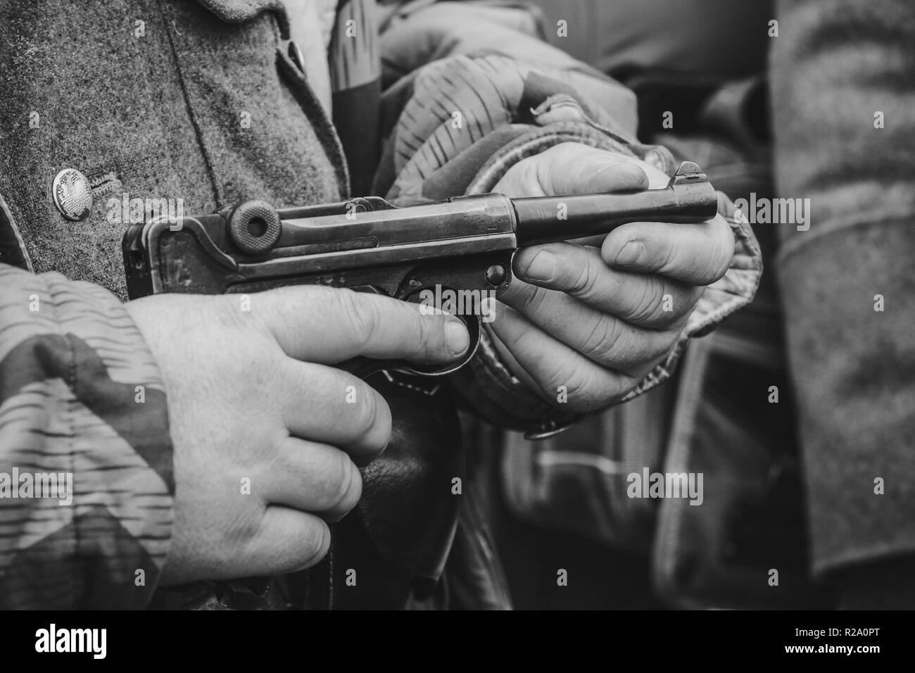 Parabellum Pistole in den Händen eines deutschen Soldaten in der Nähe. Schwarz Weiß Bild Stockfoto