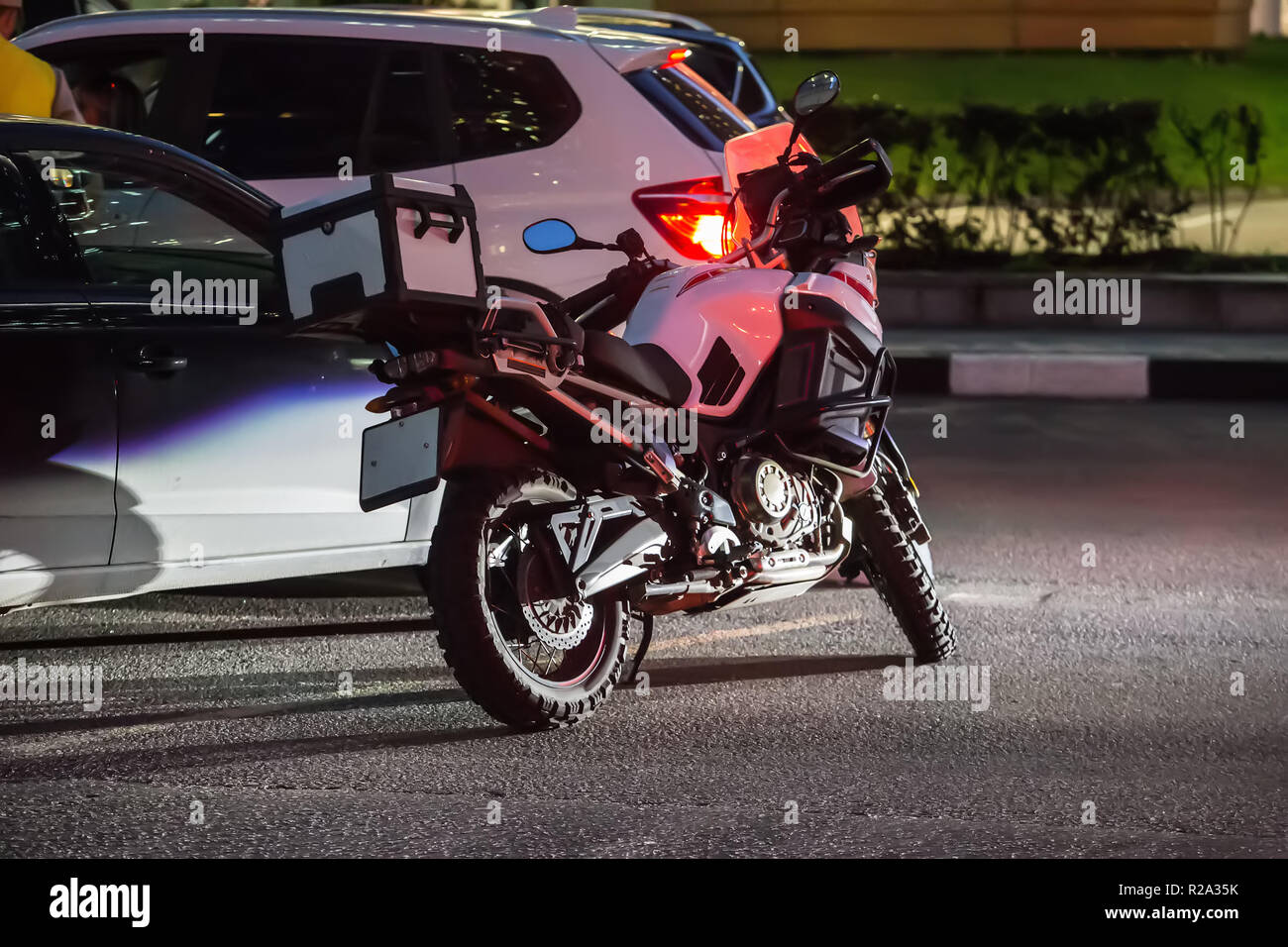 Motorrad und Pkw in der Nacht auf dem Parkplatz Stockfoto