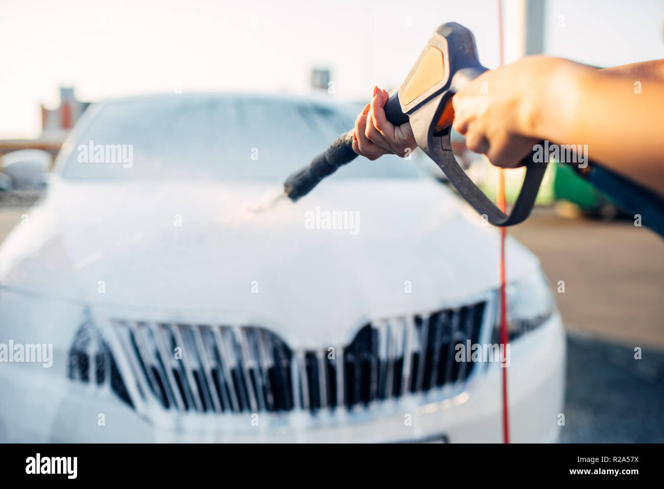 Weibliche Person Abwaschen der Schaum aus dem Auto. Junge Frau auf Self-service-Auto waschen. Outdoor Fahrzeug reinigen Stockfoto