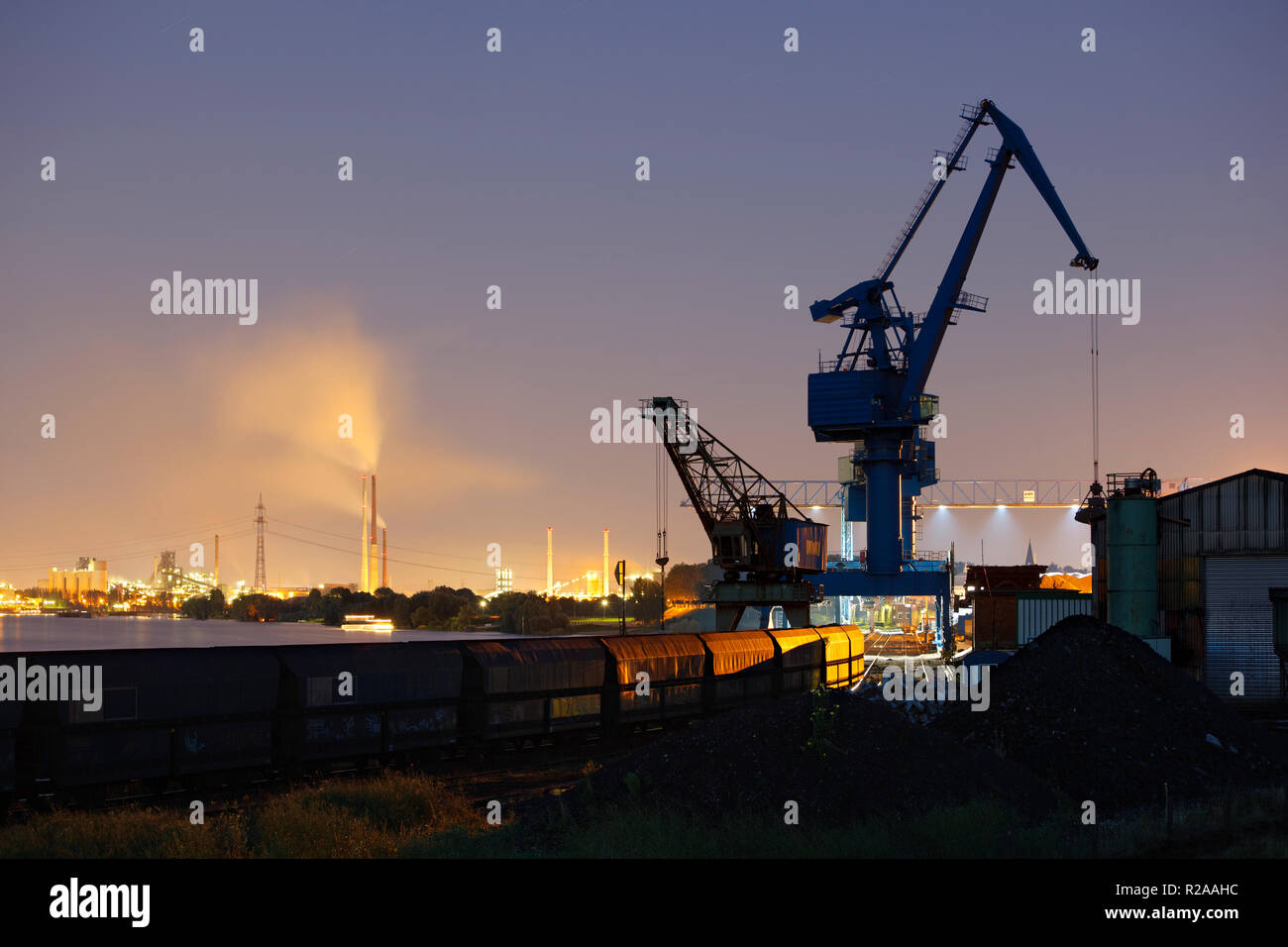 Ein Zug und ein Kran in einem Kohle Hafen an einem großen Fluss. Duisburg, Deutschland. Stockfoto