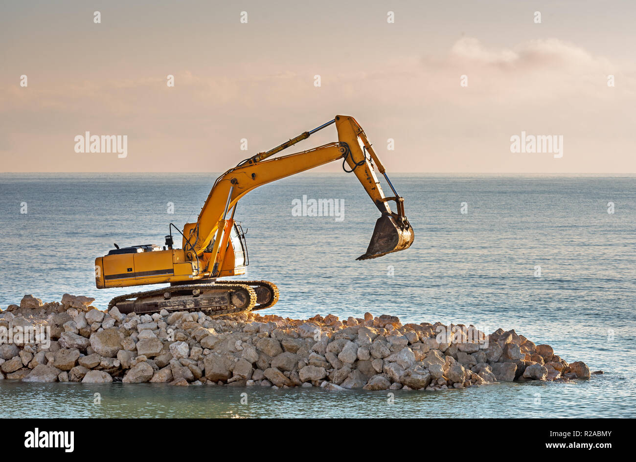 Bagger Verschiebungen Steine am Strand. Stockfoto