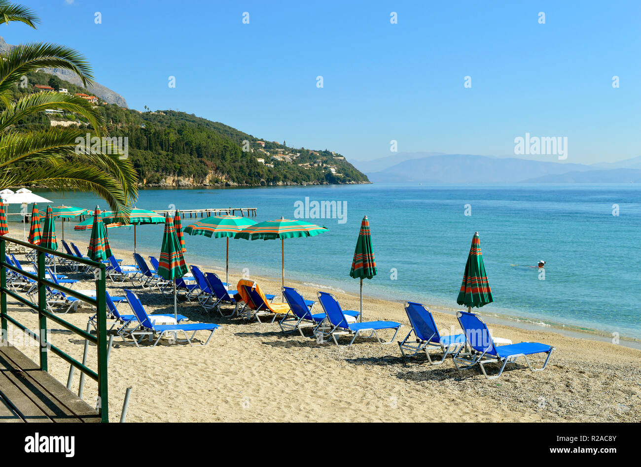 Die Sonnenliegen am Strand Ipsos in Korfu eine griechische Insel im Ionischen Meer Stockfoto