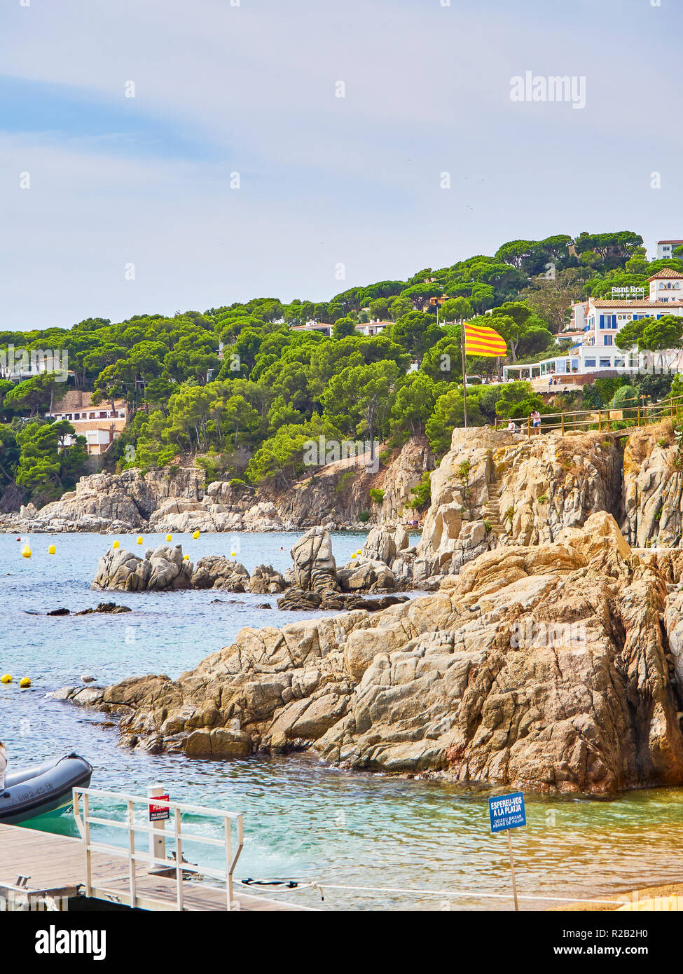 Touristen, die in Punta dels Burricaires Sicht unter dem offiziellen Flagge von Katalonien, genannt Senyera. Playa de Aro, Girona, Spanien. Stockfoto