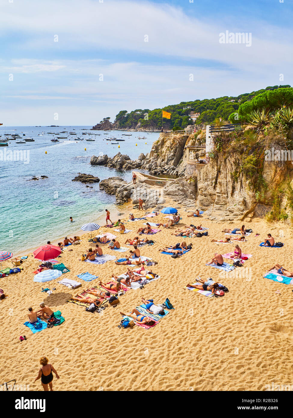 Touristen genießen Sie ein Sonnenbad in La Platgeta de Calella, einem kleinen Strand von Playa de Aro, Girona, Costa Brava, Katalonien, Spanien. Stockfoto