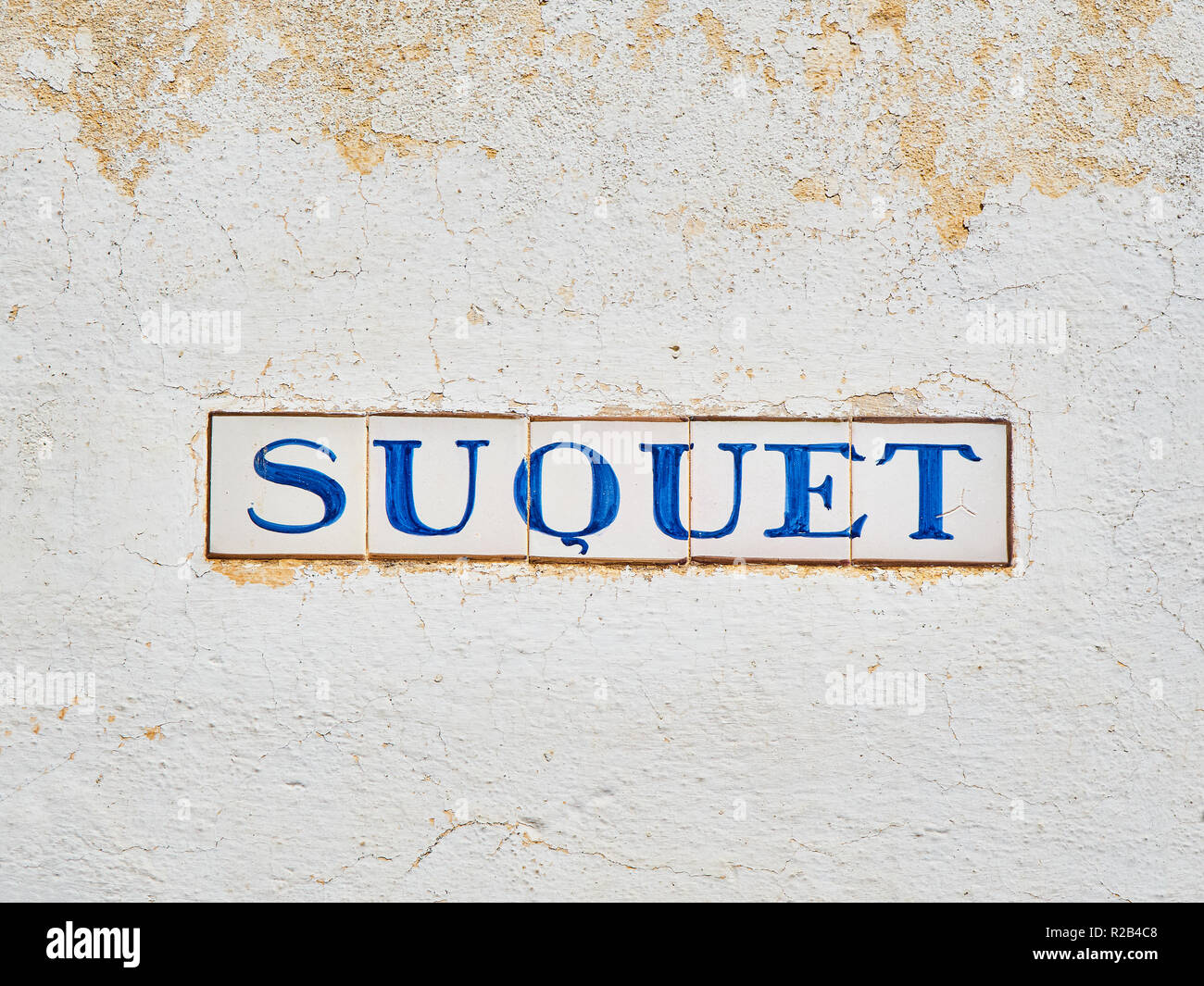 Suquet street Schild auf eine weiße Wand aus Stein. Calella de Palafrugell, Costa Brava, Girona, Catalo Stockfoto