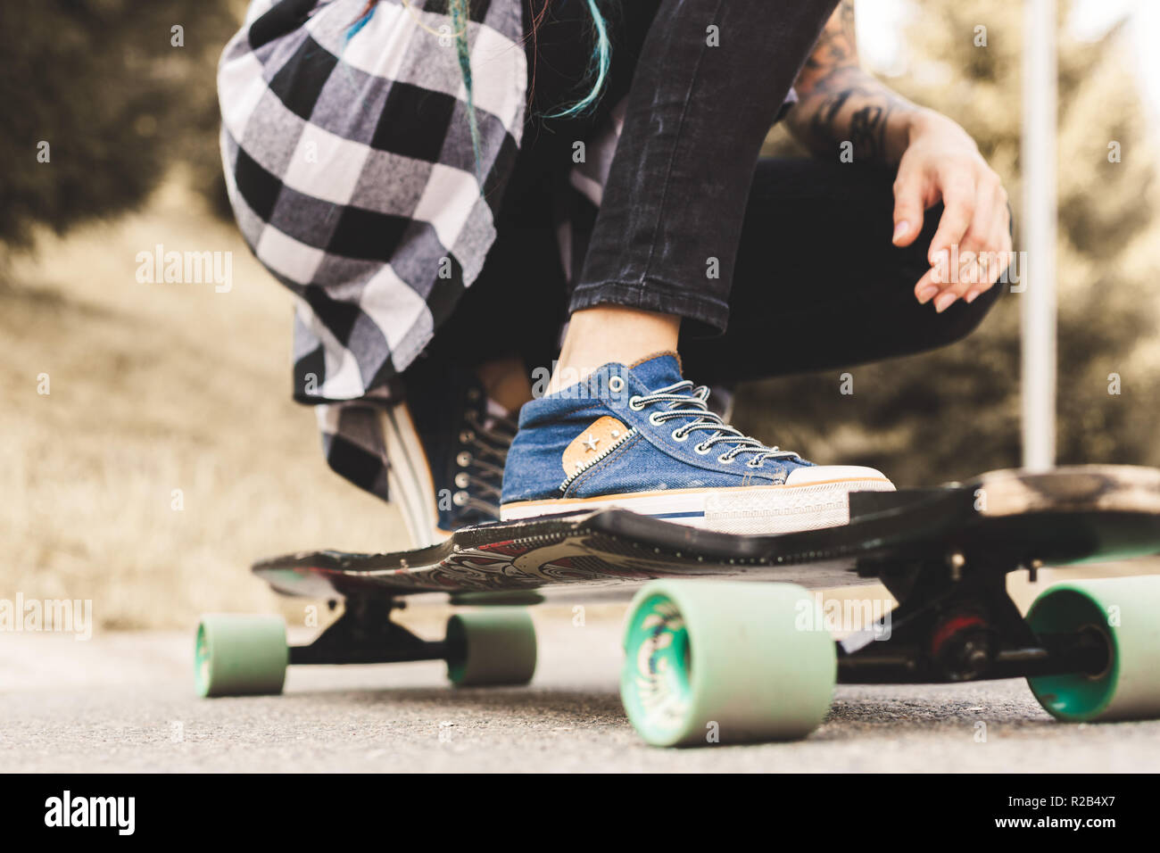 In der Nähe der Beine und Longboard stehen auf Asphalt Stockfoto