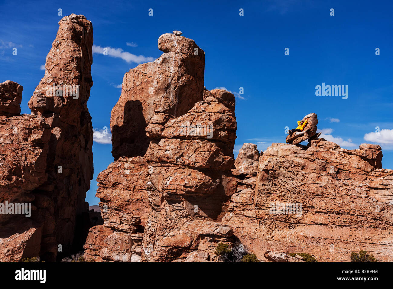 Frau sitzt oben auf dem Felsen am Rock Valley im Altiplano von Bolivien Stockfoto