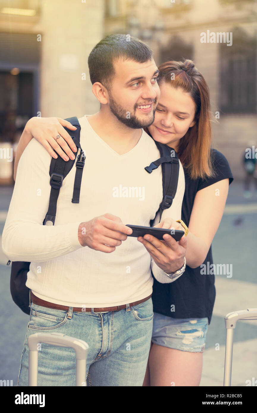 Froh, junge weibliche und männliche Touristen zusammen am Handy suchen Stockfoto