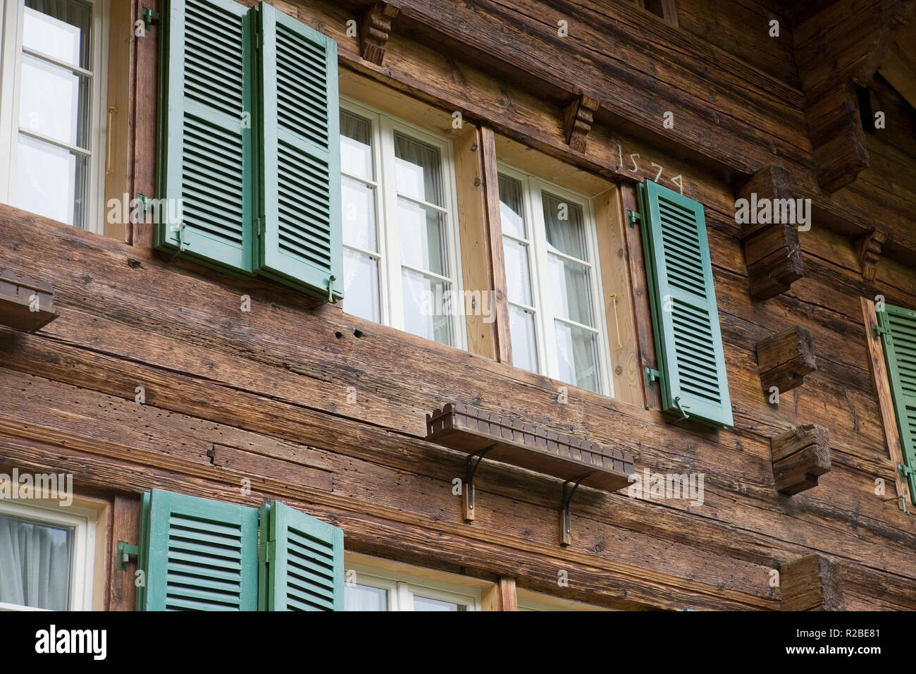 In der Nähe von Fenstern und Fensterläden eines traditionellen Holzchalet auf Alte Staatsstraße, Wilderswil: Berner Oberland, Schweiz Stockfoto