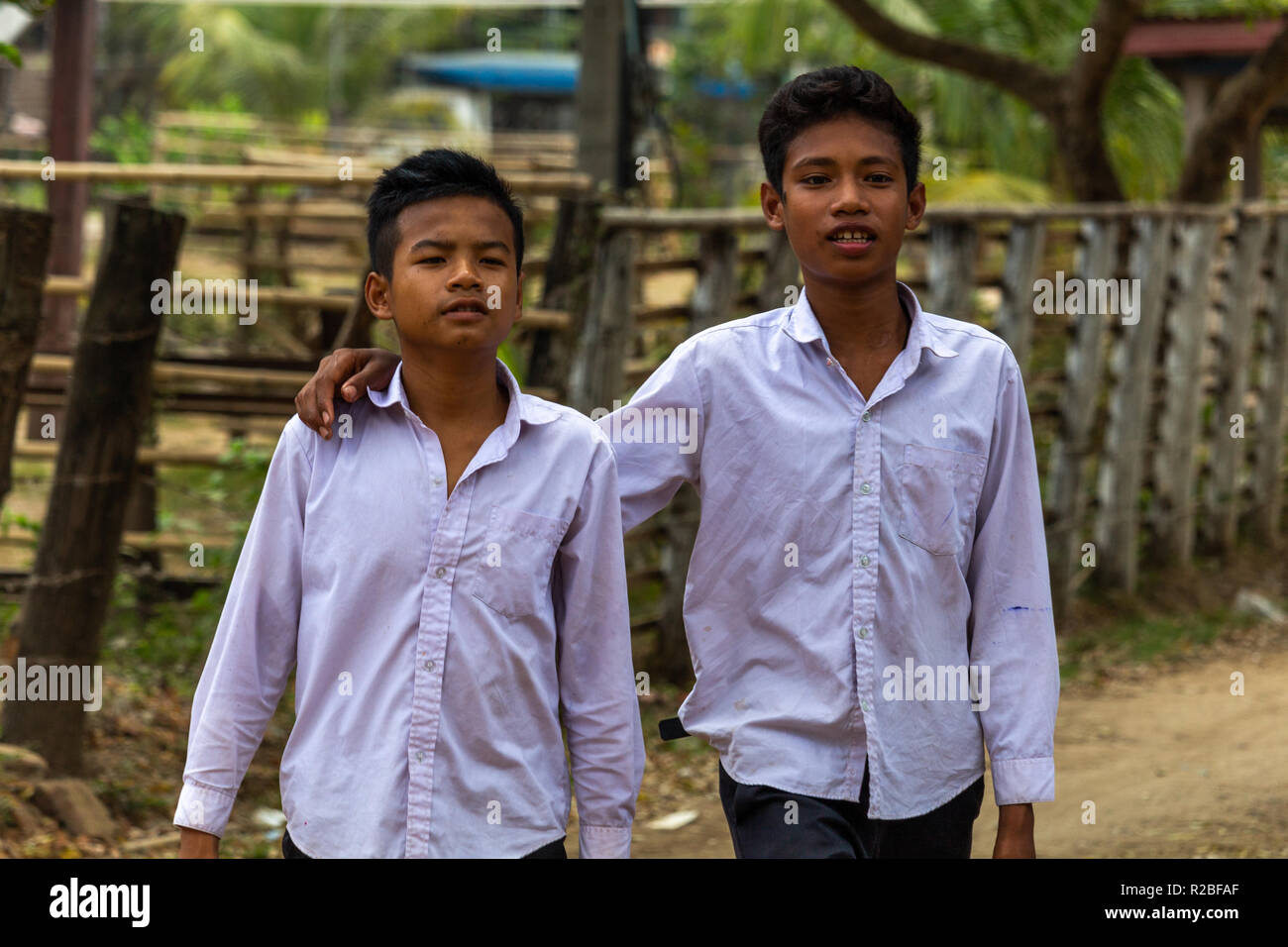 Don Det, Laos - April 24, 2018: Schule Jungen gemeinsam zu Fuß durch ein abgelegenes Dorf im südlichen Laos Stockfoto