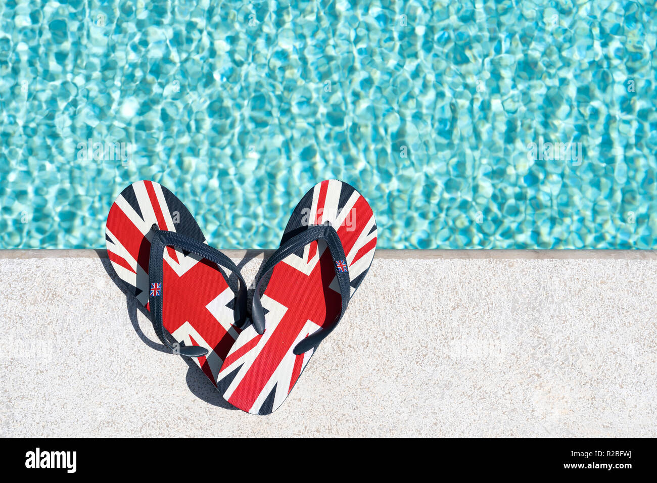 Britischer Flagge oder Union Jack gedruckt flip-flops neben dem Pool Stockfoto