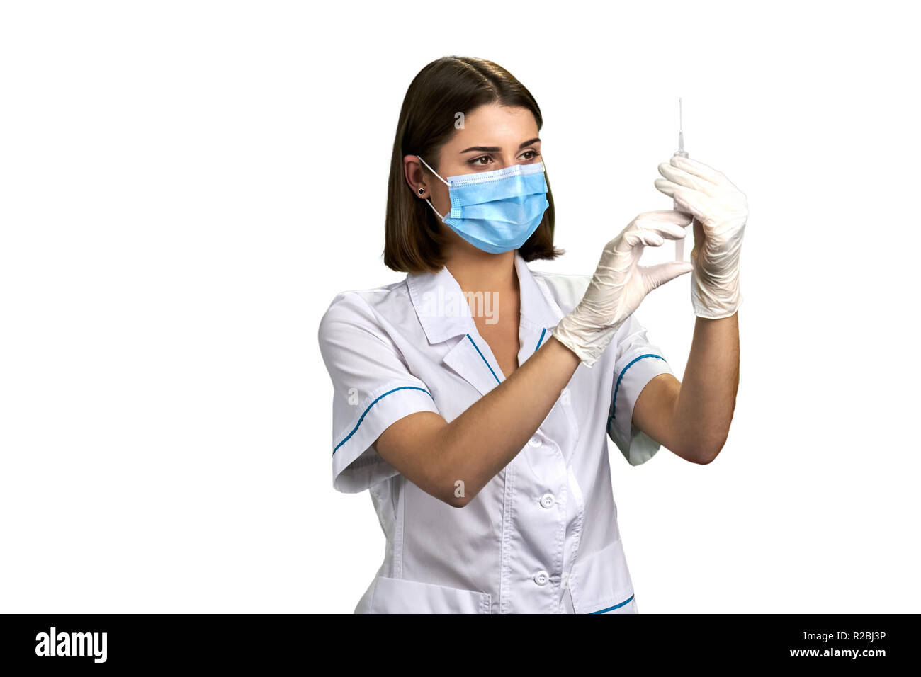 Krankenschwester mit Spritze mit Einspritzung. Junger Arzt tragen  Mundschutz und Handschuhe mit einer Spritze, auf weißem Hintergrund  Stockfotografie - Alamy