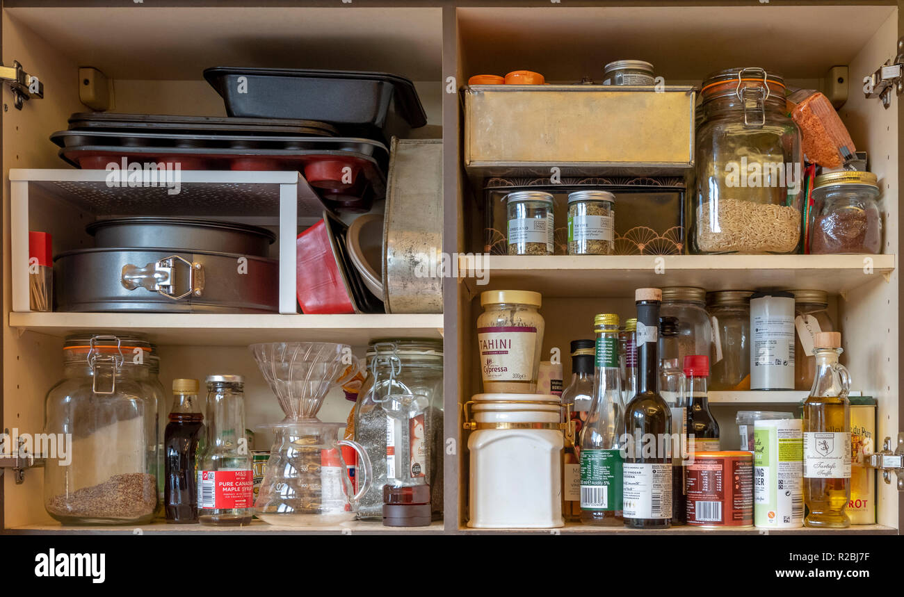 Heimische Küche Schränke innen mit gespeicherten Zutaten, Backformen, Kaffeekannen und Nahrung. Stockfoto