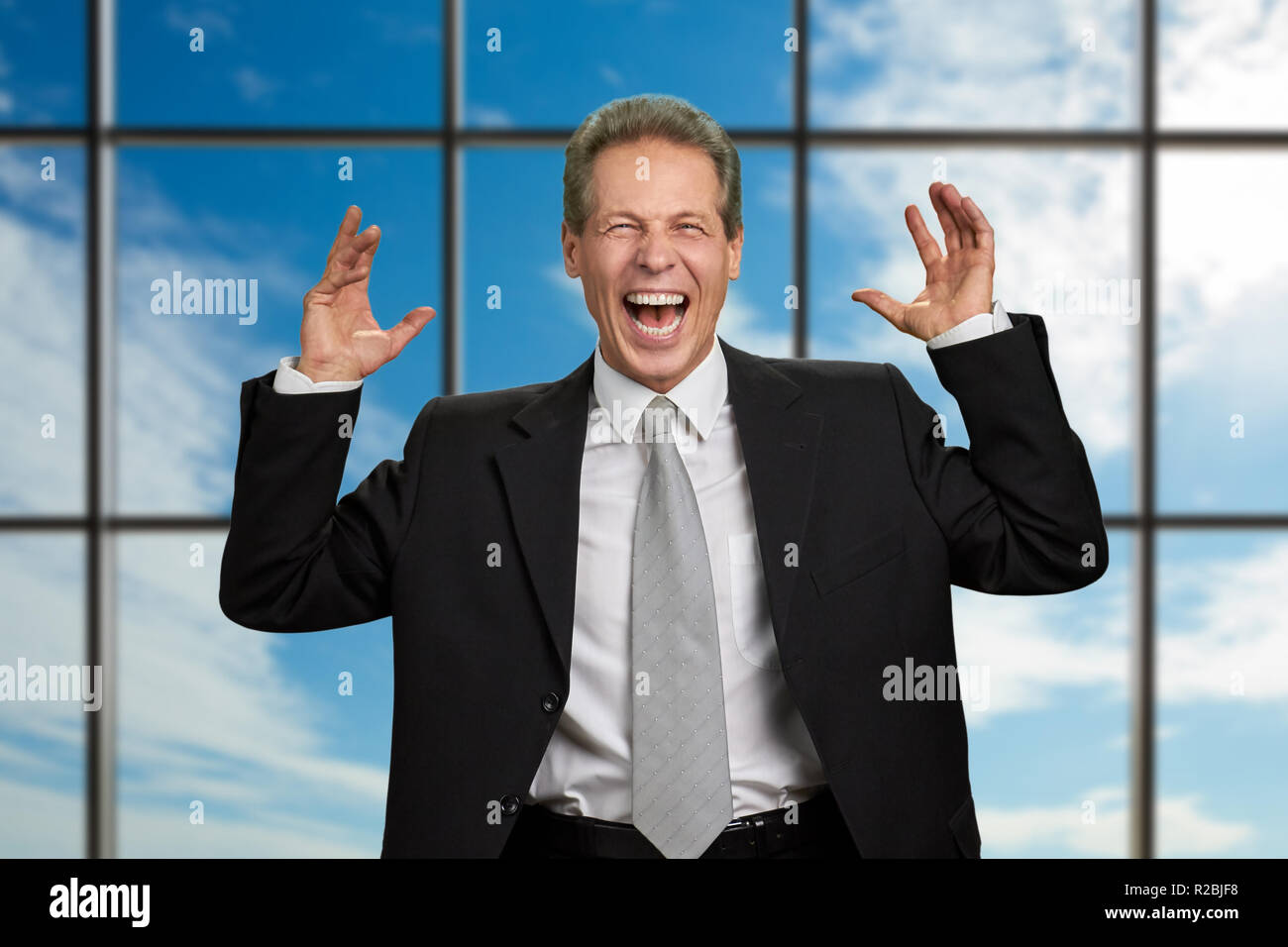 Boss erhobenen Händen in Aufregung. Aufgeregt lachen Geschäftsmann hob seine Hände zum Himmel Hintergrund. Menschlichen Ausdrucksformen des Glücks. Stockfoto