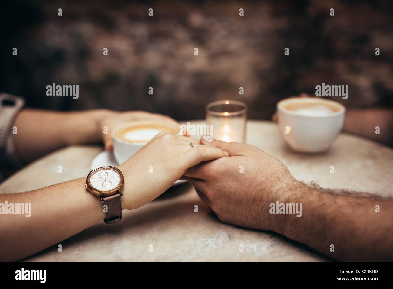 Paar auf ein Date in einem Restaurant sitzen, Kaffee trinken. Mann hält die Hand seiner Freundin in einem Café sitzen. Stockfoto
